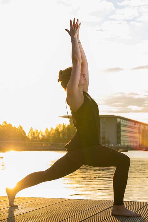 Yoga teacher in a pose at sunset